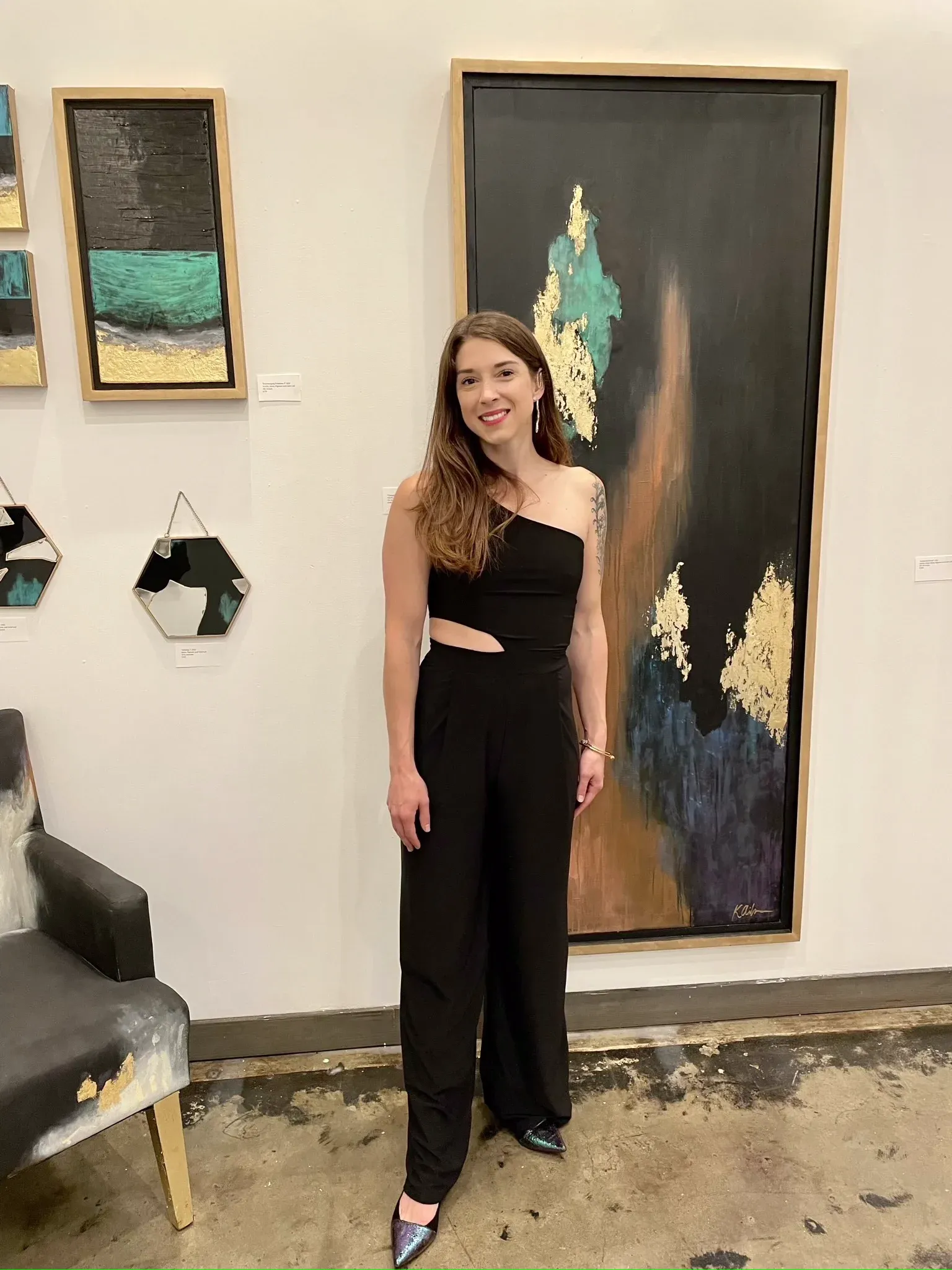 Kelly beside one of her tall gold leaf originals at a gallery show