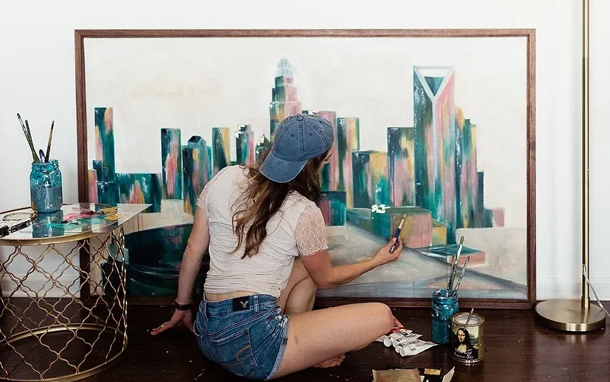 Kelly painting a large Charlotte skyline canvas